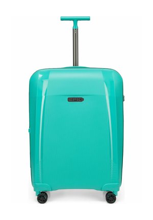Valise rigide turquoise avec poignée noire prolongée et quatre roulettes noires pivotantes, logo de la marque centré à l'avant.