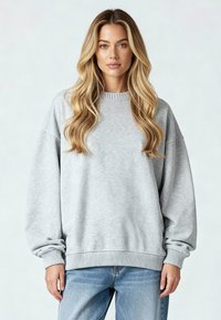 Vaaleanharmaa collegepaita, joka on valmistettu pehmeästä kankaasta. Paita on varustettu ribatulla kauluksella ja hihansuilla. Väljät mitat ja pudotetut olkaimet, yhdistettyinä sinisiin farkkuihin.