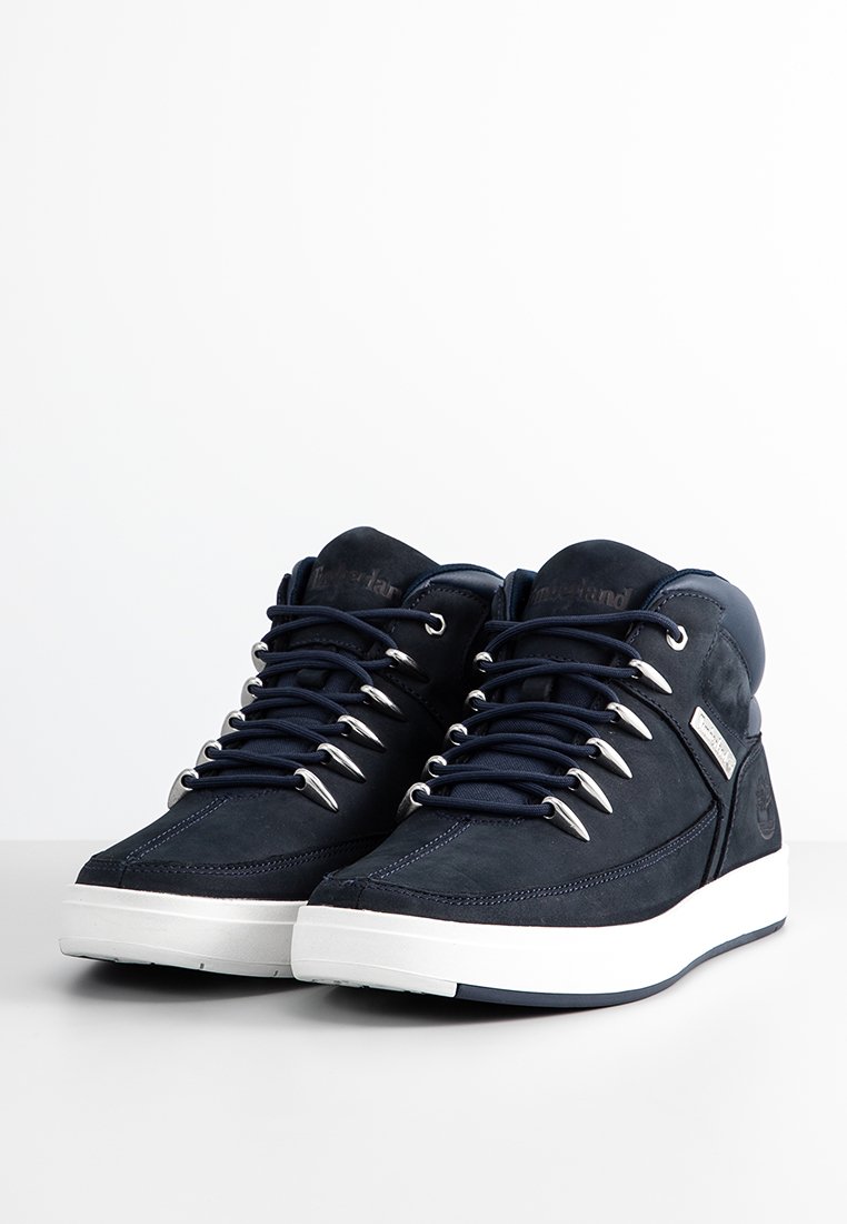 Sneaker alte color blu navy realizzate in suede, con occhielli argentati, lacci neri e una suola in gomma bianca con il marchio sul lato.