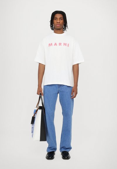 Bílé oversized tričko s červeným kostkovaným vzorem a textem "MARNI", zkombinované s světle modrými džíny. Černé boty a dvoubarevná taška.
