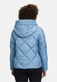 Jasnoniebieska pikowana kurtka z kapturem, z diamentowym wzorem i elastycznymi mankietami. Gładka faktura, zaprojektowana z myślą o ciepłu i komforcie.