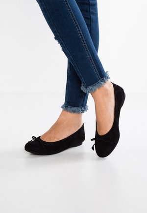 Zwarte suede ballerina's met een ronde neus en een klein strikdetail. Gekocht bij een paar cropped blauwe denim jeans met franjes aan de onderkant.