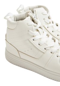 Białe sportowe buty za kostkę wykonane z gładkiej syntetycznej skóry, z zamknięciem na zamek błyskawiczny, sznurowanym designem oraz teksturowaną podeszwą.
