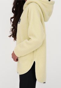 Texturerad ljusgul fleecetröja med huva och sidospår, med en svart logotypmärke och mjukt, varmt tyg.