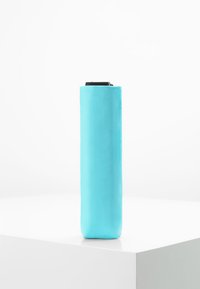 Een turquoise cilindervormige waterfles met een gladde matte afwerking en een zwarte dop bovenop, gekenmerkt door een minimalistisch ontwerp.