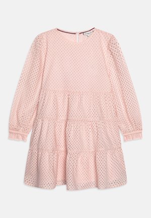 Vestito rosa chiaro con maniche lunghe a sbuffo, balze a più livelli e piccoli ritagli circolari. Completato da una chiusura con bottoni sul retro e una texture morbida.