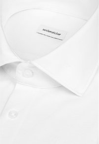 Chemise blanche à col pointu et boutons blancs, avec une étiquette de marque cousue à l'intérieur du col portant la mention "seidensticker."