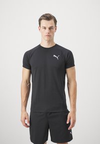 Melnas sporta krekliņš, kas izgatavots no viegla materiāla, ar īsām piedurknēm, apaļu kakla izgriezumu un sudraba Puma logo kreisajā krūtī.