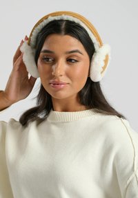 Cuffie in finta pelliccia marrone con interno morbido e fascetta imbottita. Le cuffie presentano una superficie esterna liscia e una texture bianca e pelosa.