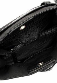 Sac à main en cuir noir avec une finition texturée, intérieur spacieux, compartiments zippés et fermeture à pression magnétique. Doublé de tissu.