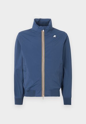 Giacca leggera blu navy con collo alto, zip frontale con dettagli arancioni e bianchi, e piccolo logo bianco sul petto.