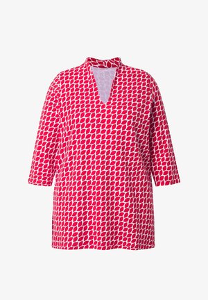 Czerwono-biała tunika z dekoltem w kształcie litery V i rękawami do połowy ramienia, ozdobiona powtarzającym się geometrycznym wzorem liści.