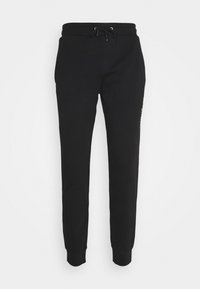 Schwarze Jogginghosen aus weichem Stoff mit slim fit, elastischem Taillenbund mit Kordelzug und dezentem Logo-Detail an der Seite.