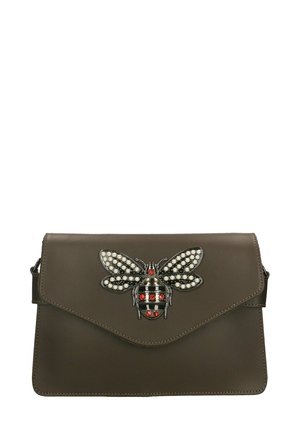 Borsa a tracolla in pelle marrone con un distintivo ornamento a forma di ape metallica decorata con perle e dettagli rossi. Chiusura a patta con un design elegante.