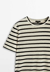 Randig t-shirt i lätt tyg; har svarta och krämfärgade horisontella ränder, rund halsringning och avslappnade korta ärmar.