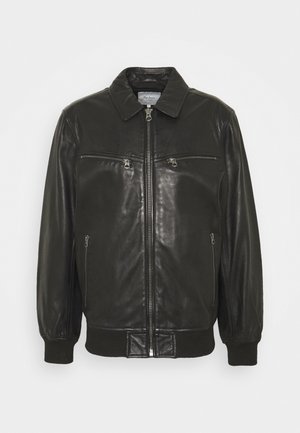 Schwarze Lederjacke mit Frontreißverschluss, zwei horizontalen Reißverschlusstaschen auf der Brust, zwei vertikalen Reißverschlusstaschen an den Seiten sowie gerippten Bündchen und Saum.