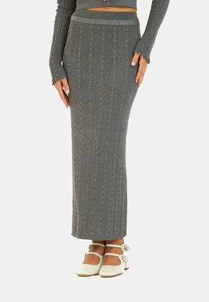 Falda de punto acanalada gris con líneas verticales y adornos dispersos. Incluye una blusa a juego con mangas largas y puños ondulados.