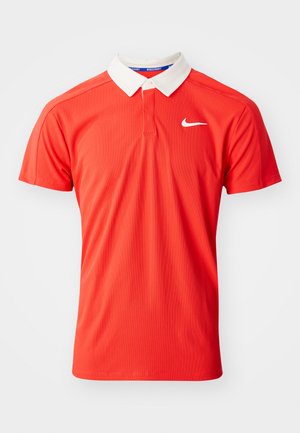 Red polyester polo shirt with a white collar, featuring a button placket and a small white Nike logo on the chest. Plain texture.