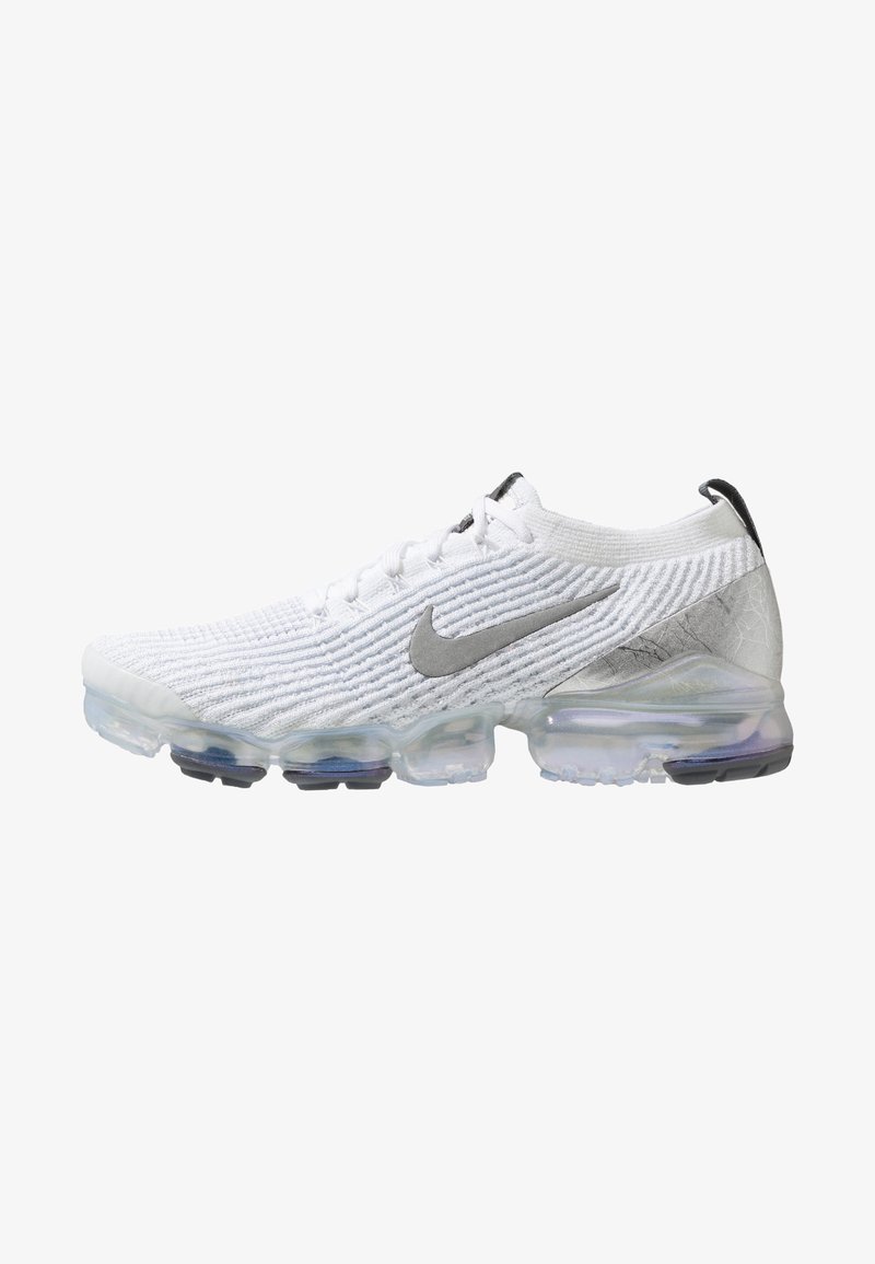 Bílé tenisky Nike Air VaporMax s texturovaným svrškem, které mají stříbrný swoosh, průhlednou vzduchovou podrážku a černé gumové akcenty.