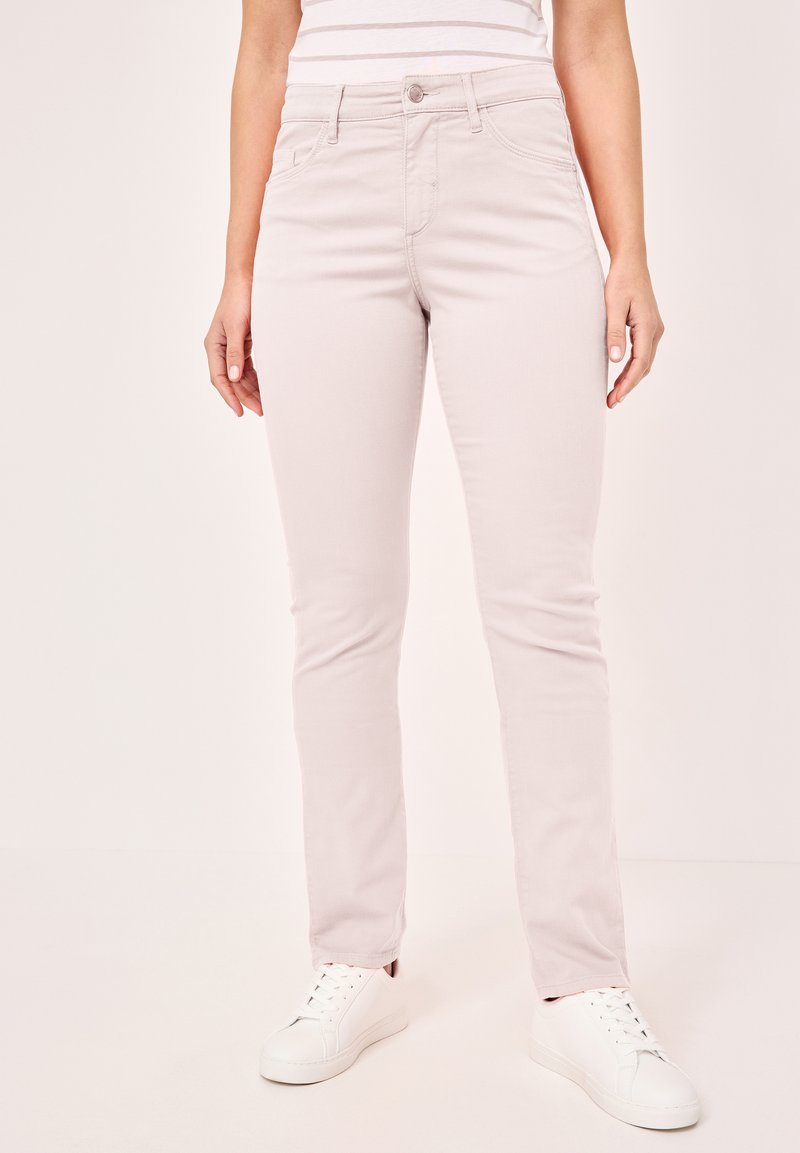 Helle rosa Slim-Fit-Jeans aus Baumwollmischung, mit frontalen Taschen, Gürtelschlaufen und Reißverschluss mit Knopfverschluss. Kombiniert mit weißen Sneakers.