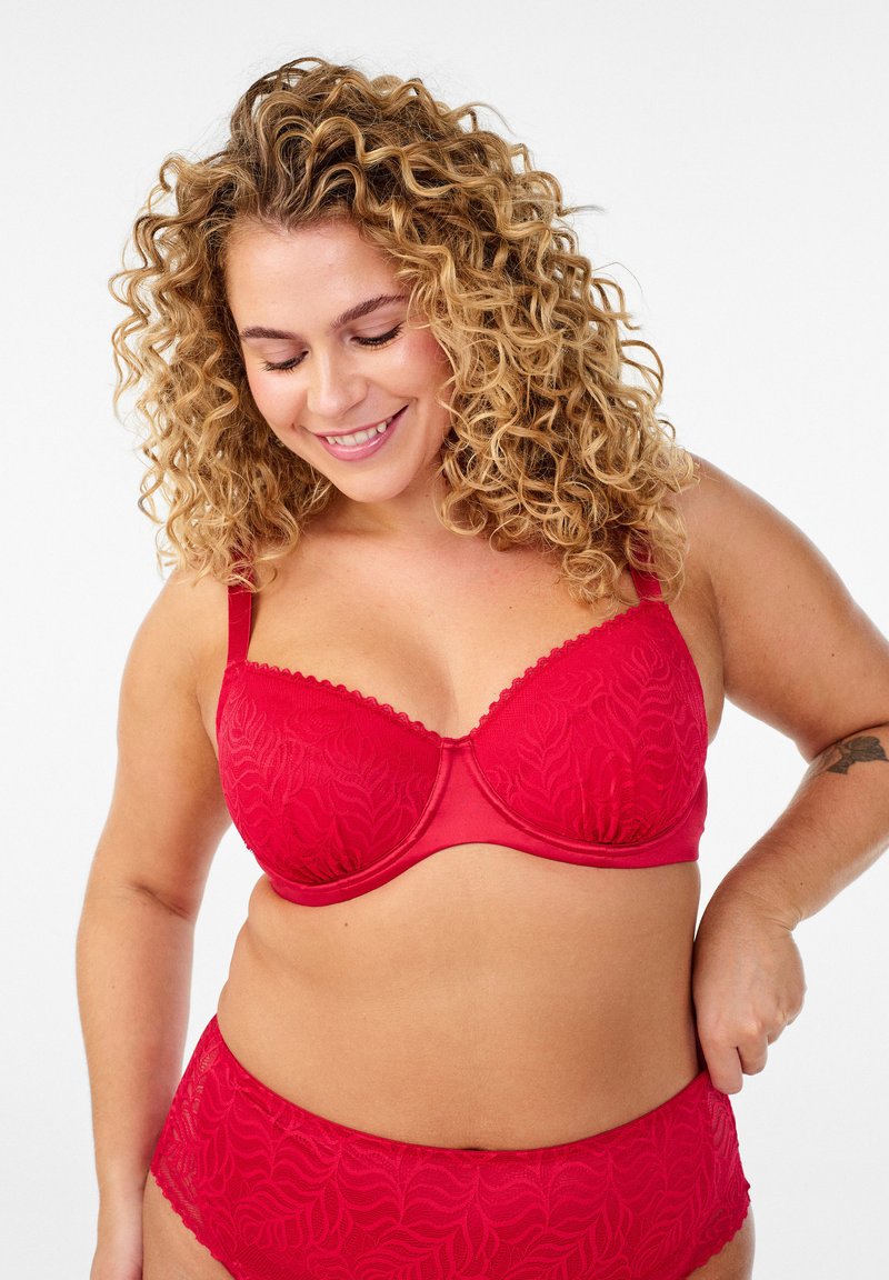 Czerwony biustonosz i pasujące majtki z wysokim stanem w kwiatowy wzór. Biustonosz posiada fiszbiny, koronkową lamówkę i regulowane ramiączka. Gładka faktura.