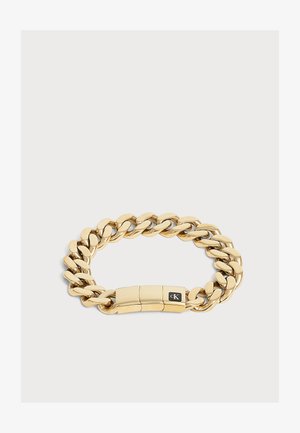 Bracelet chaîne à gros maillons en or avec un fermoir lisse présentant un petit logo carré noir gravé avec "cK".