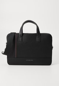 Black leather laptop bag with smooth texture, double handles, adjustable shoulder strap, and a red-white-blue accent stripe. Iconic logo displayed.