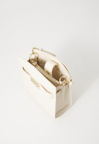 Borsa a mano in pelle bianca con design strutturato, accessori in oro, manico superiore e tasca interna con zip. Accento frontale minimalista.