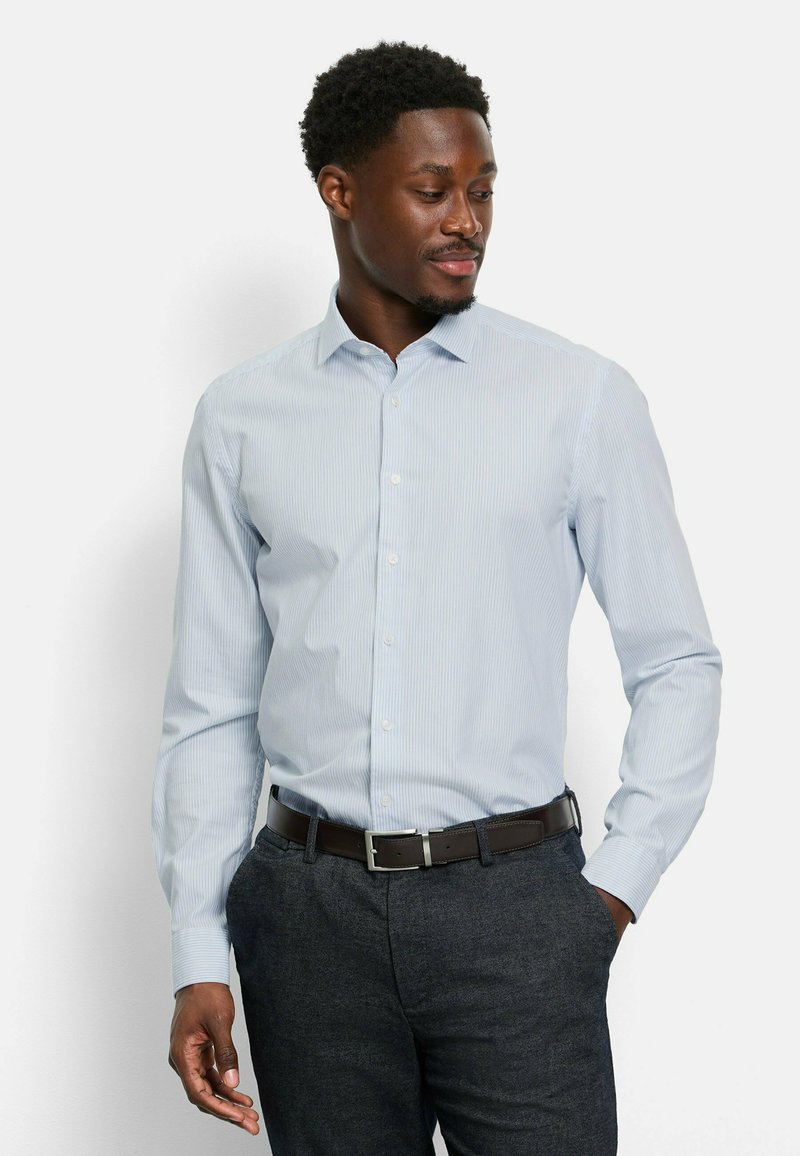 Helles blau gestreiftes Hemd mit Knopfkragen, langen Ärmeln und slim fit, kombiniert mit dunkelgrauen Hosen und einem braunen Gürtel.