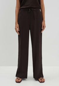 Brede broek in donkerbruin stof, met een elastische tailleband met trekkoord en verticale naaddetails.