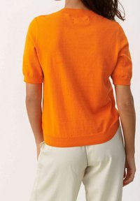 Kurzärmeliger Pullover in leuchtendem Orange, mit figurbetontem Schnitt und geripptem Kragen, Saum und Bündchen. Schlichte, glatte Struktur.