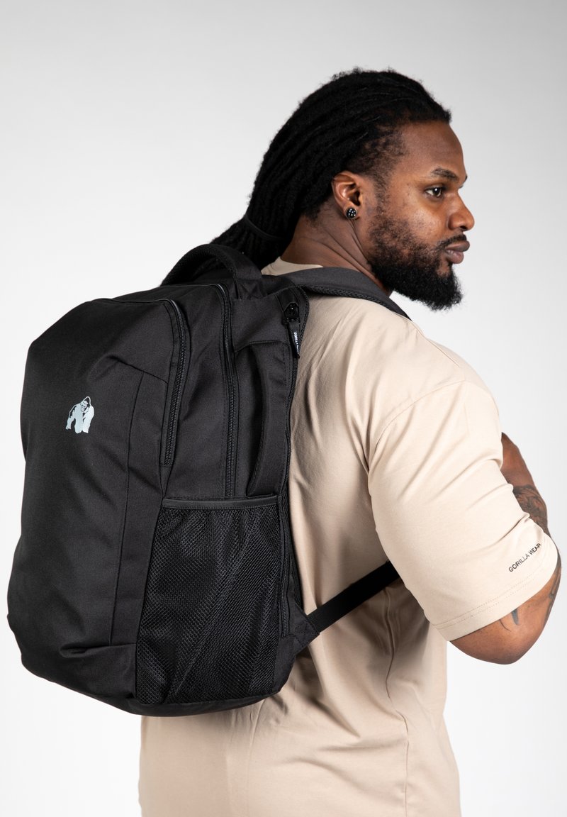 Zwarte rugzak van duurzaam materiaal, voorzien van een mesh zijvak, dubbele ritscompartimenten en een kenmerkend logo op het voorpaneel.