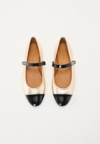 Bailarinas metálicas doradas con una puntera y tira en charol negro. Forro interior suave y forma redondeada para un diseño clásico.