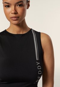 Top atletico senza maniche di colore nero con un design aderente, caratterizzato da strisce verticali argentate e la scritta "FREDDY" sul lato. Texture liscia.