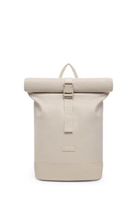Beige roll-top backpack with central buckle strap, handle loop at top, and "Larkson Hamburg" label on front bottom section.