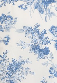 Tkanina w kwiatowy wzór z niebieskimi odcieniami na białym tle, prezentująca szczegółowe wzory kwiatów i liści o miękkiej strukturze.