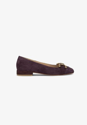 Chaussure plate en daim violet avec un bout arrondi, présentant un accent en métal doré et un talon bas. Texture lisse avec un design ajusté.