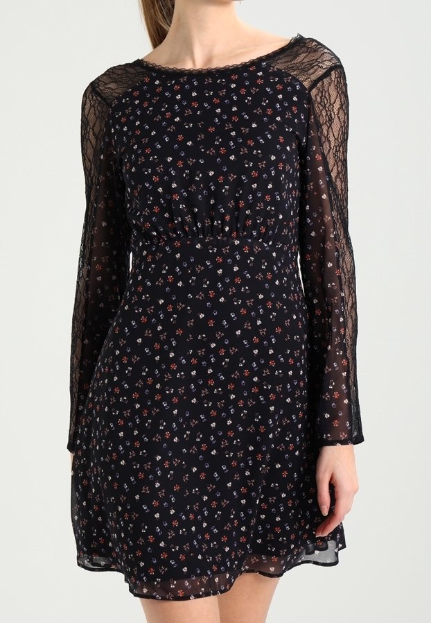 Langärmeliges schwarzes Kleid mit Blumenmustern in Rot, Blau und Weiß. Transparente Spitzenärmel, taillierter Bund und fließender Rock.