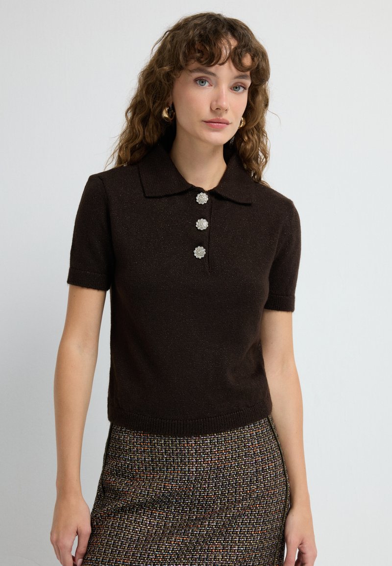 Hnědá polo košile s krátkým rukávem a límečkem, se třemi dekoračními knoflíky ve tvaru květin a přiléhavým střihem.