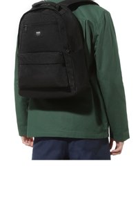 Svart tygryggsäck med rektangulär form, med två fickor med blixtlås och logotyp på framsidan. Buren på ryggen av en person.