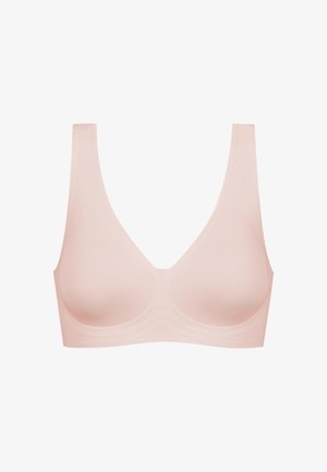 Soutien-gorge sans couture rose clair avec des bretelles larges et un décolleté en V profond ; fabriqué en tissu lisse et extensible. Sans agrafes ni armatures.