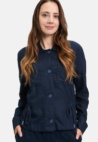 Granatowa kurtka zapinana na guziki z mieszanki lnu, z dwoma przednimi kieszeniami, detalami ze sznurkiem w talii oraz klasycznym kołnierzykiem.