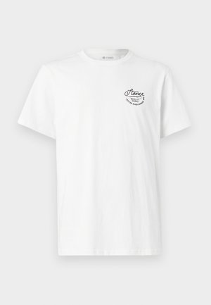 T-shirt de algodão branco com decote redondo e mangas curtas, apresentando um logótipo bordado preto no lado superior esquerdo.