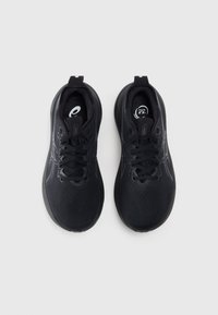 Scarpe da ginnastica nere con superficie liscia, punta arrotondata, design con lacci e sottili accenti laterali. Logo visibile sulla linguetta.