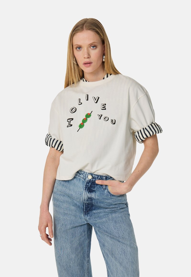 Witte katoenen T-shirt met de tekst "I OLIVE YOU", een groene olijfafbeelding en gestreepte omgeslagen mouwen. Draagt samen met hoge, blauwe denim jeans.
