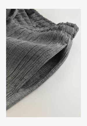 Gray textured fabric with vertical stripes, featuring an elastic waistband and smooth edges. Focus on creases and subtle sheen.