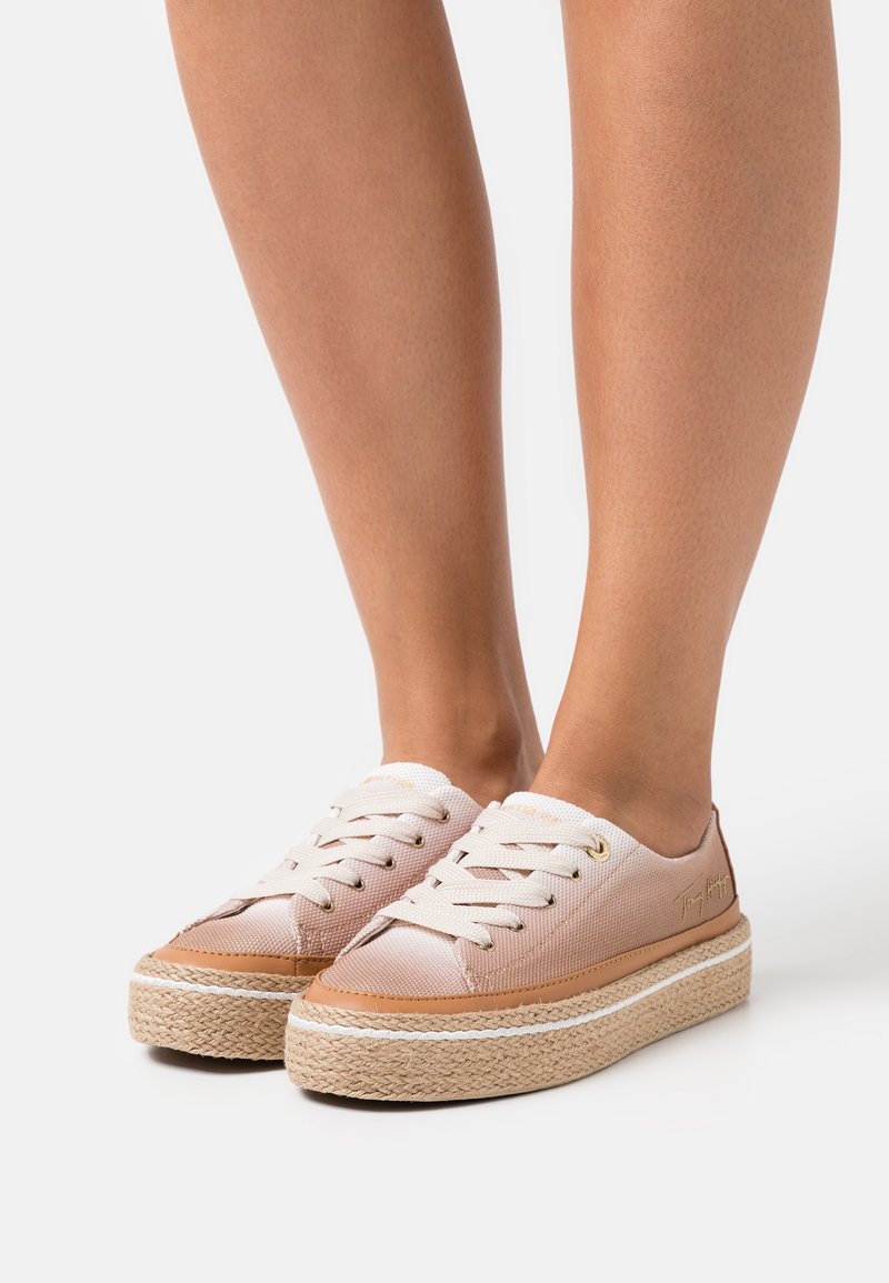 Růžové plátěné tenisky s tkanými juty podrážkami. Mají bílé tkaničky, zlaté očky a decentní logo na boku.