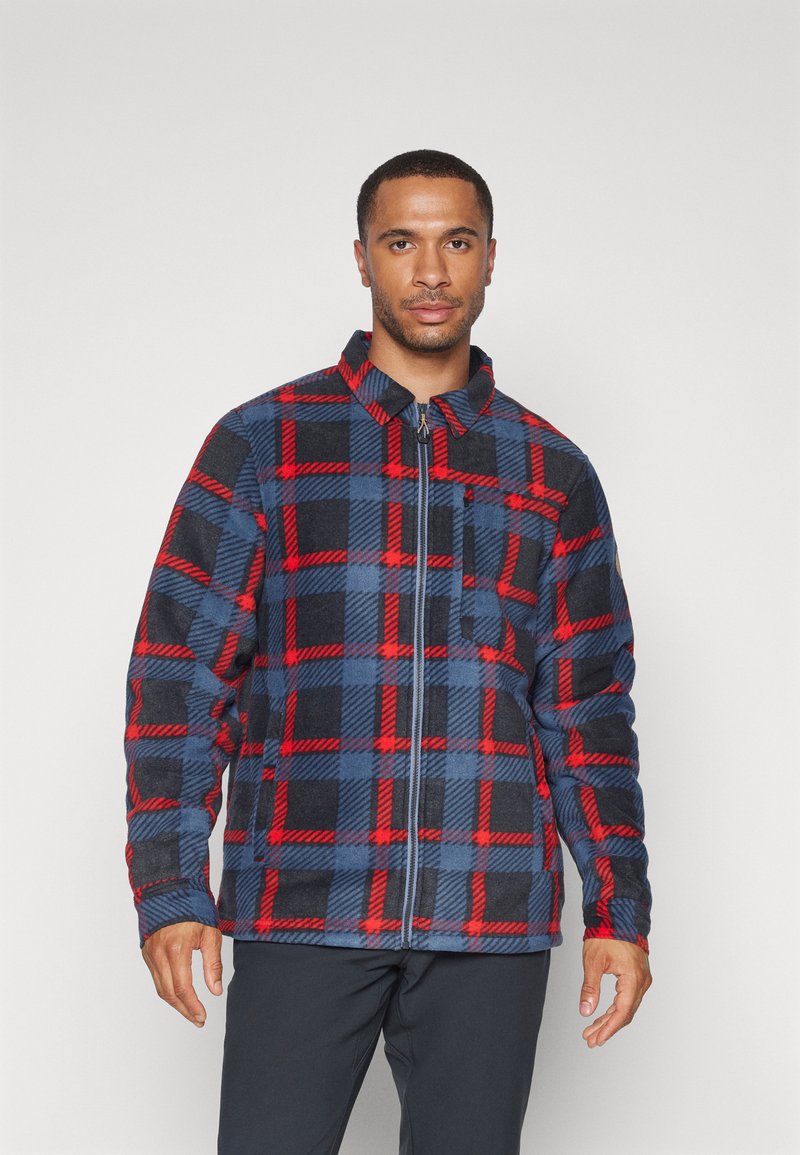 Kockovaná bunda v modro-červeno-čiernej farbe z fleecového materiálu. Disponuje zipsom vpredu, golierom a dlhými rukávmi s uvoľneným strihom.