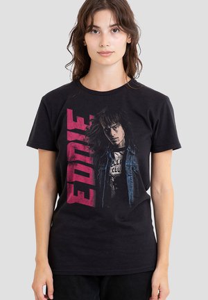 Schwarzes Baumwoll-T-Shirt mit einem grafischen Motiv eines Charakters und dem Schriftzug "EDNIE" in kräftigen roten Buchstaben. Kurzarm und Rundhalsausschnitt.