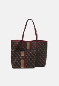 Ciemnobrązowa torba na ramię i dopasowana saszetka w paski w kolorze tan i burgundowym, z wzorem logo Guess oraz burgundowymi uchwytami na białym tle.